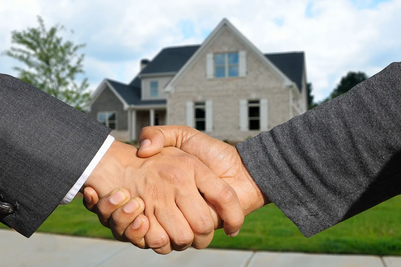 A handshake in front of a house