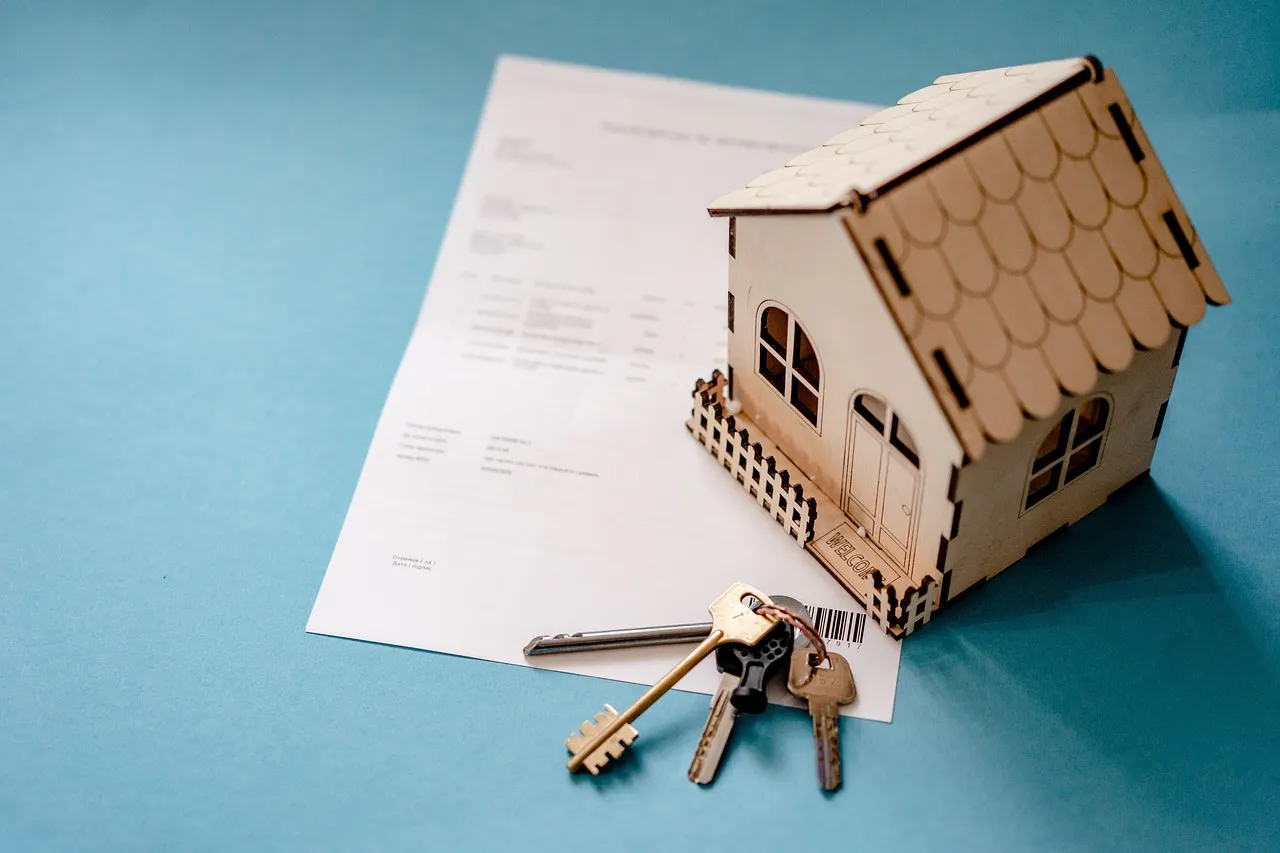 A model house, keys and a signed document on a desk